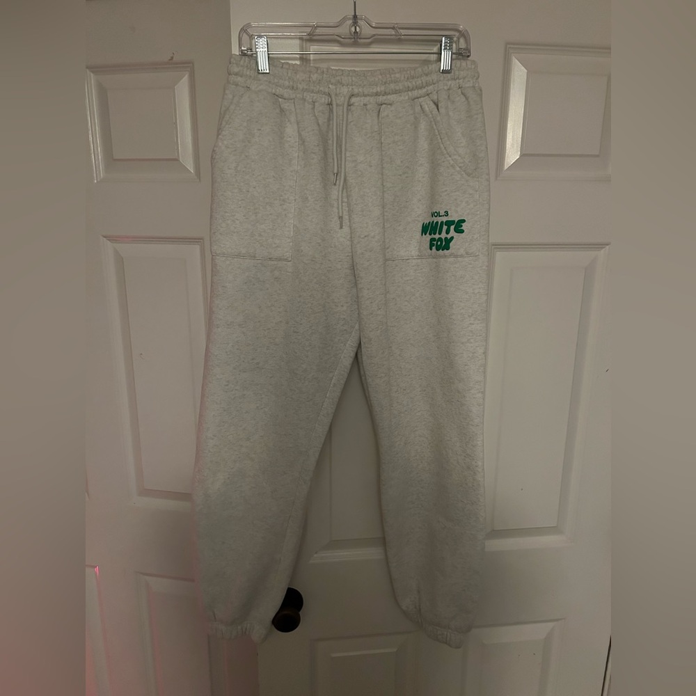 White fox grey sweatpants with green lettering